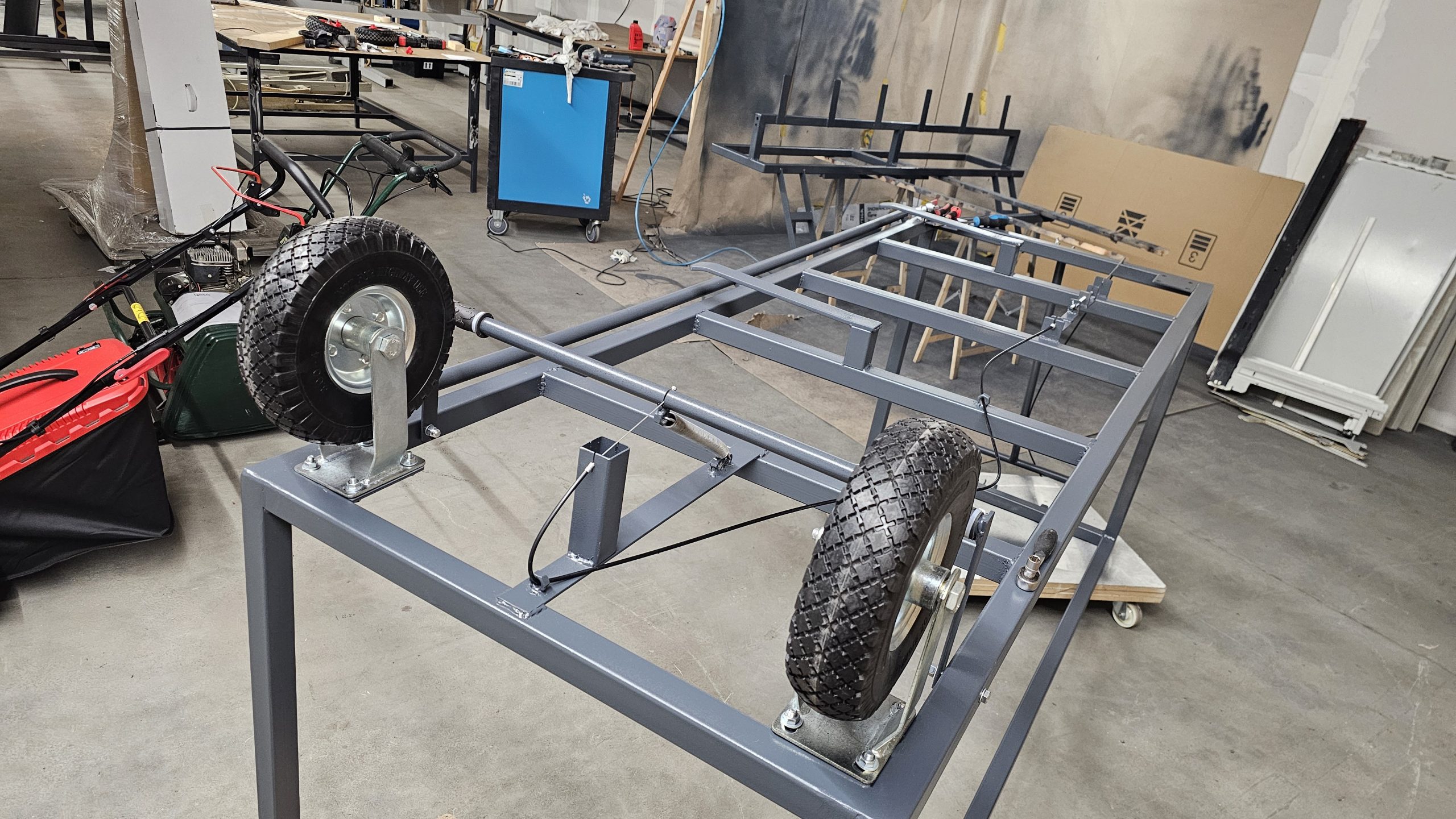 Unterseite eines Transportwagens mit Rollen und Handbremse